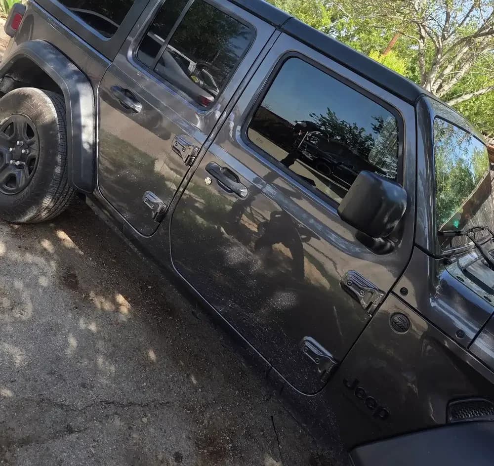 Side doors and windows of a dark Jeep.