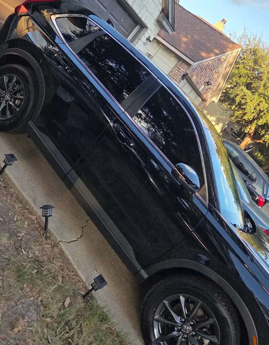 Side view of a black SUV with dark windows and silver trim.