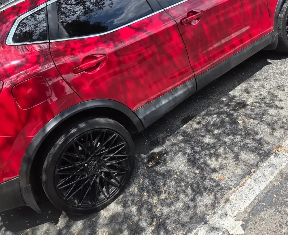 Close view of the side windows and body of a red SUV.